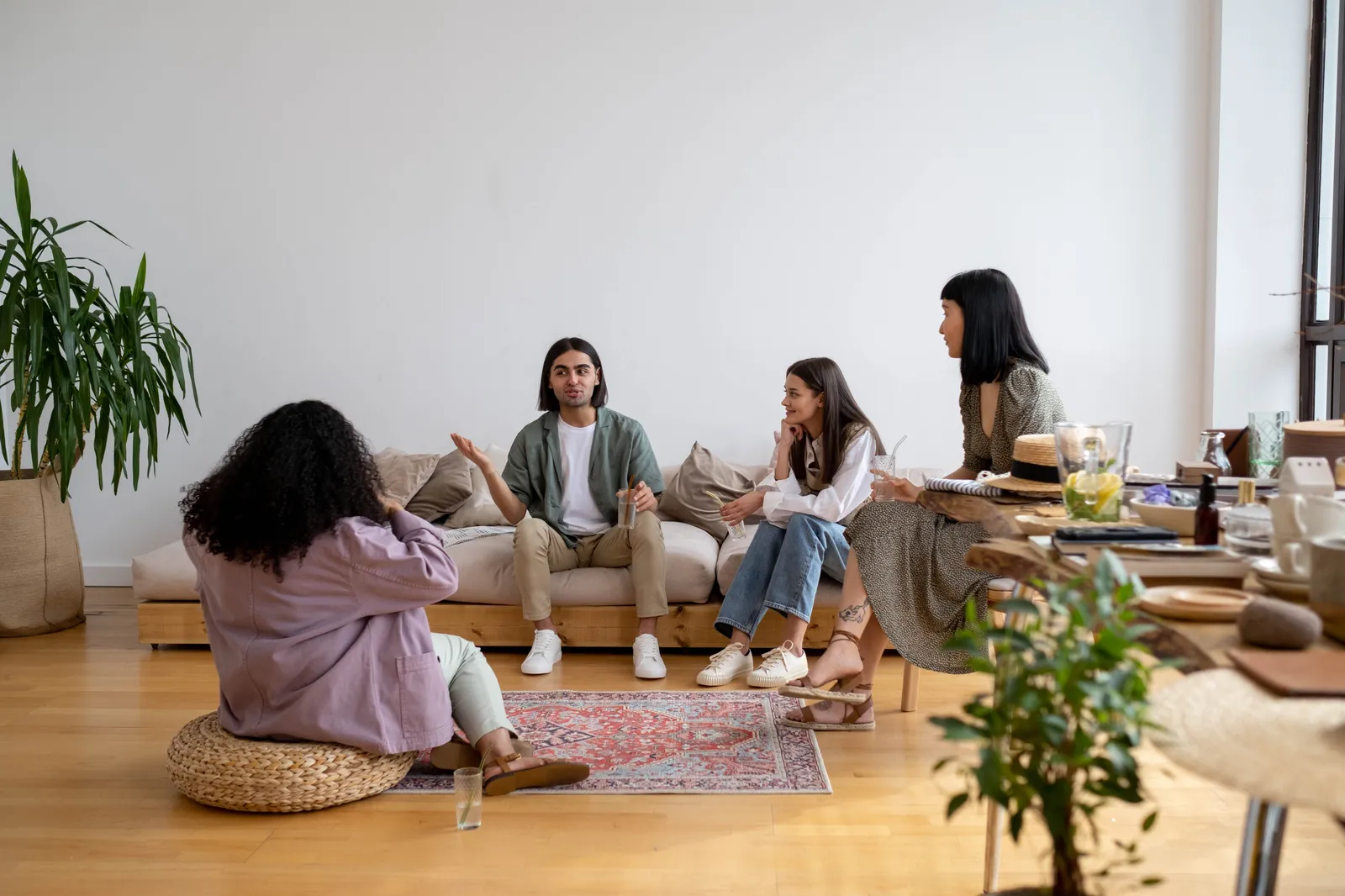 Eine kleine Gruppe sitzt in einem Wohnzimmer zusammen und spricht miteinander.